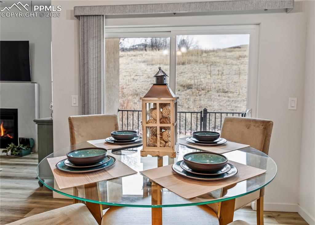 Image 15 of 46: Dining room featuring wood finished floors and a glass covered fireplace