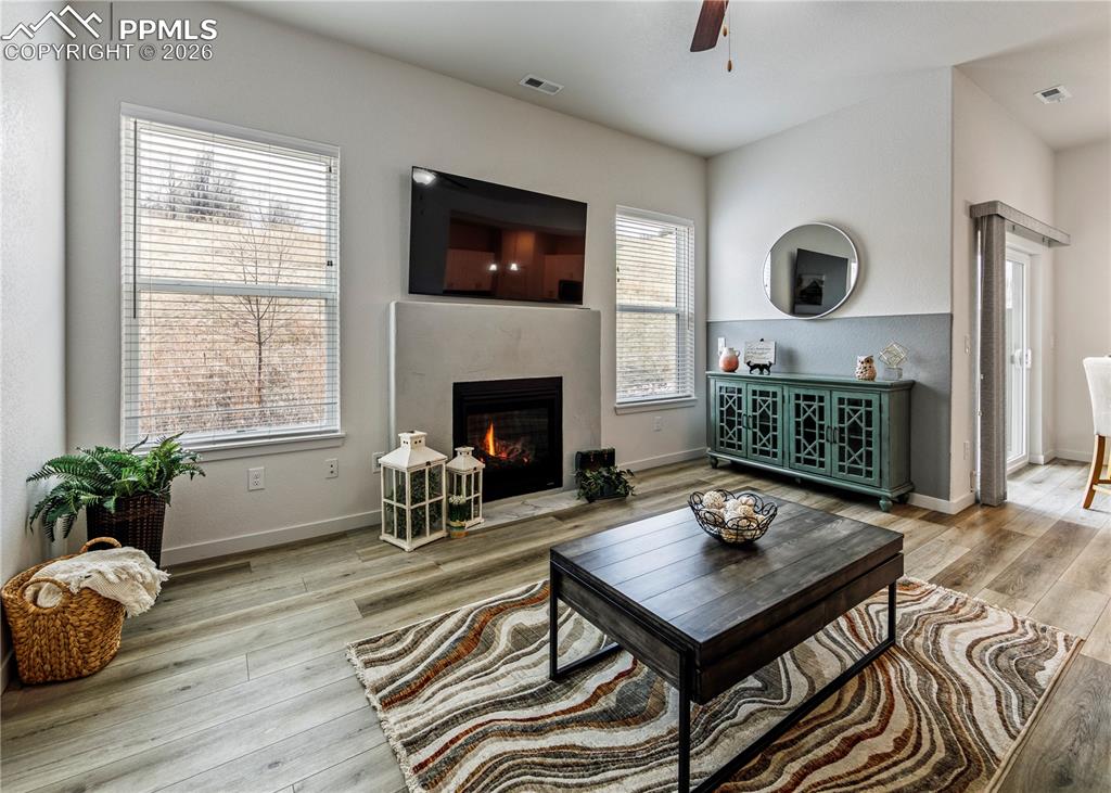 Image 17 of 46: Living area with light wood finished floors, ceiling fan, and a high end fi