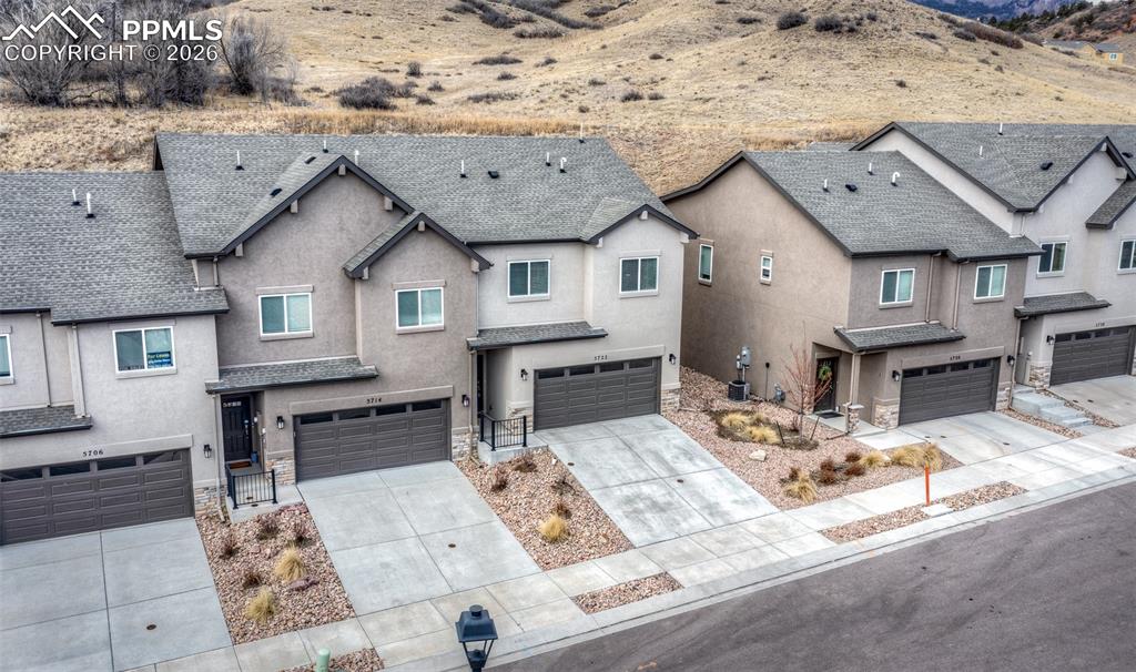 Image 2 of 46: Traditional home featuring a garage, stucco siding, concrete driveway, roof