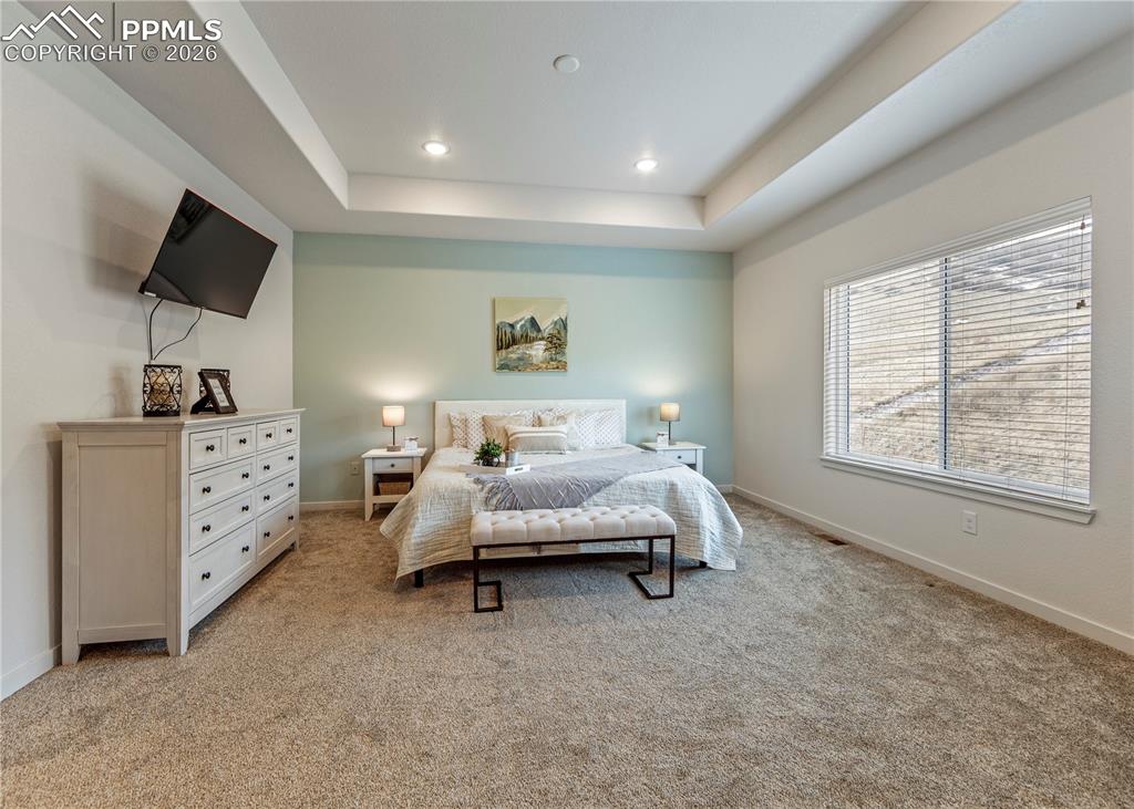 Image 23 of 46: Bedroom with carpet, a raised ceiling, and recessed lighting