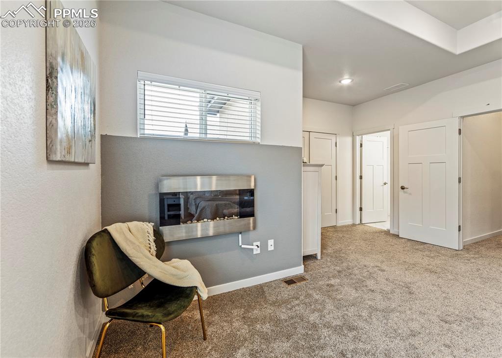 Image 25 of 46: Living area with carpet flooring and baseboards