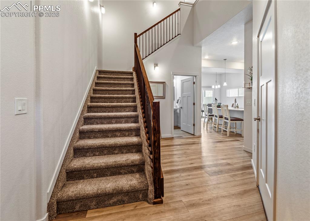 Image 3 of 46: Stairway featuring wood finished floors and a high ceiling