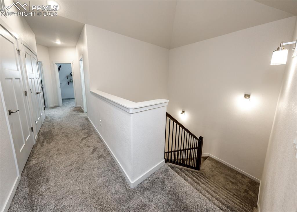 Image 41 of 46: Corridor featuring an upstairs landing and dark colored carpet