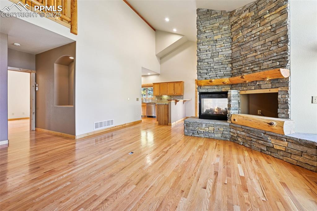 Image 10 of 42: Unfurnished living room featuring a stone fireplace, light wood finished fl