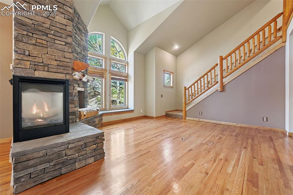 Image 11 of 42: Unfurnished living room featuring light wood finished floors, high vaulted 