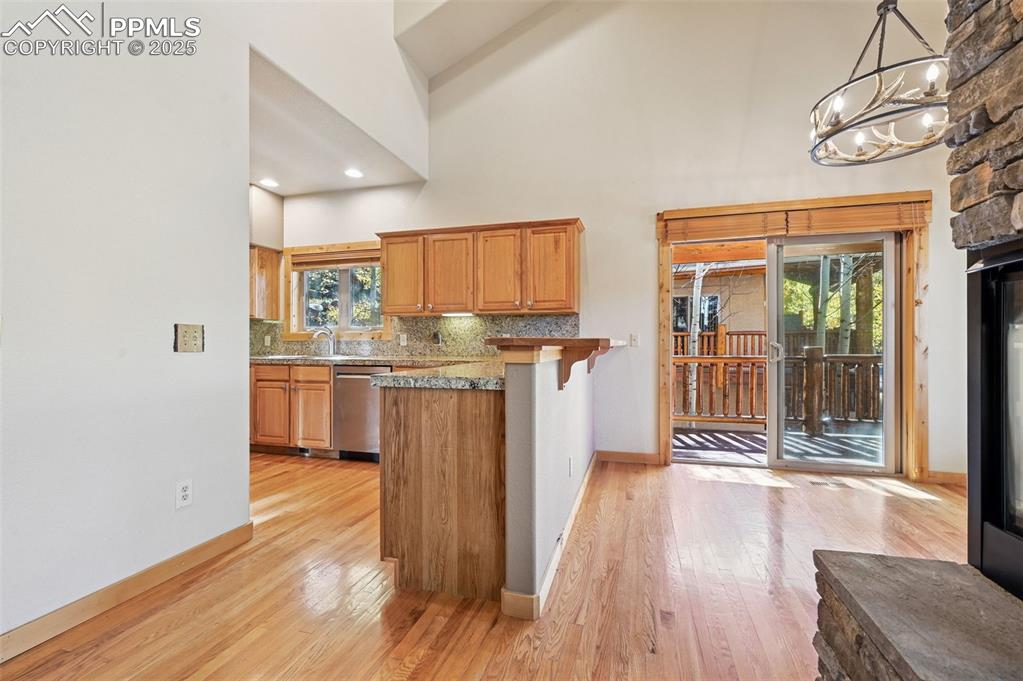 Image 12 of 42: Kitchen featuring a breakfast bar area, backsplash, high vaulted ceiling, a