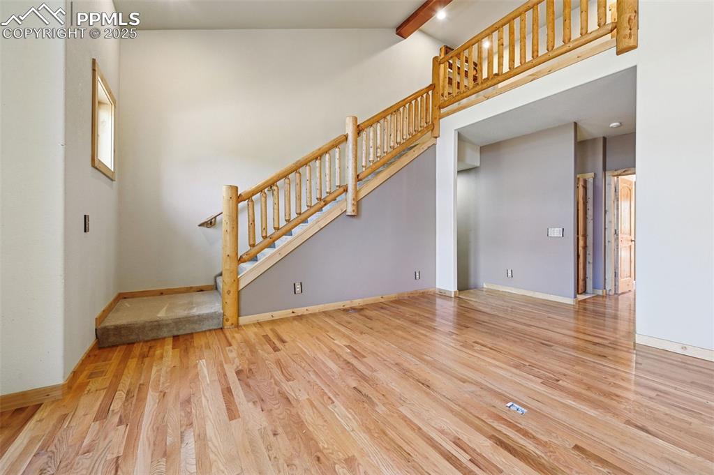 Image 13 of 42: Unfurnished living room featuring light wood-style floors, a high ceiling, 