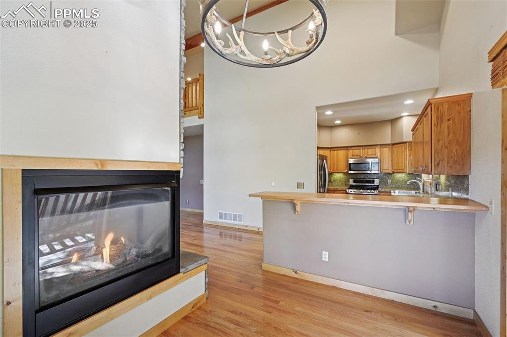 Image 16 of 42: Kitchen featuring a kitchen breakfast bar, backsplash, light countertops, l