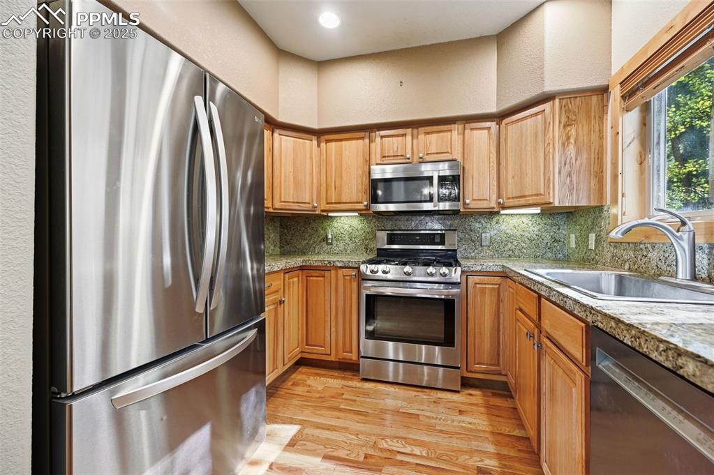 Image 20 of 42: Kitchen featuring appliances with stainless steel finishes, a textured wall