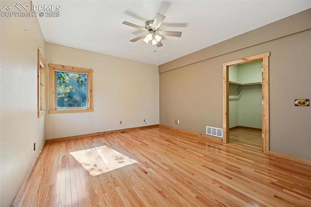 Image 24 of 42: Unfurnished bedroom featuring a spacious closet, light wood-style floors, a