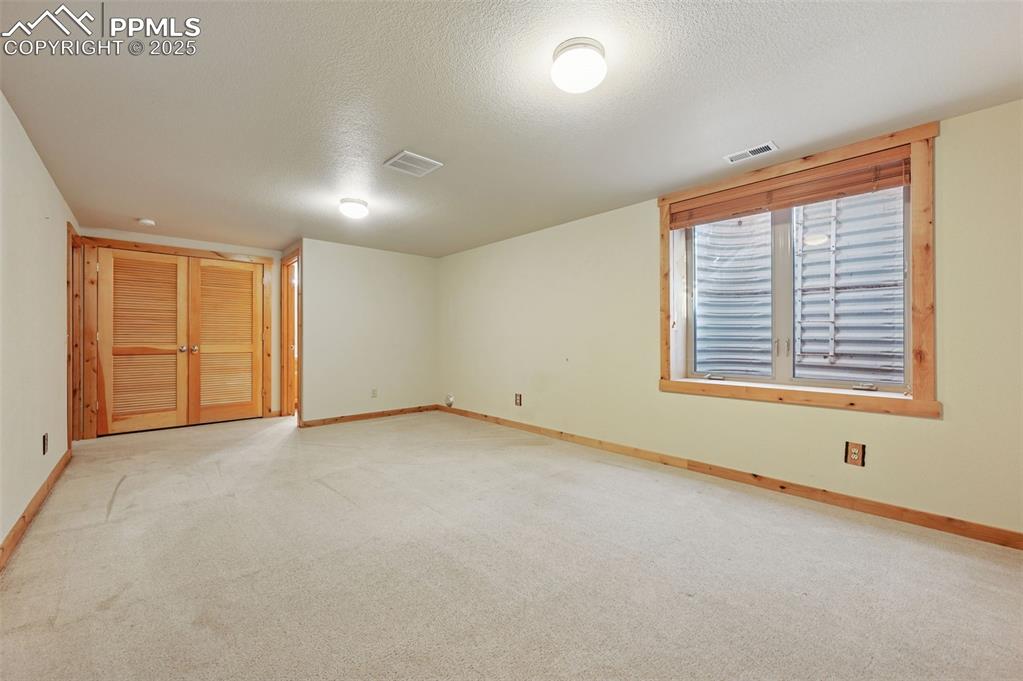 Image 6 of 42: Empty room featuring a textured ceiling and light carpet