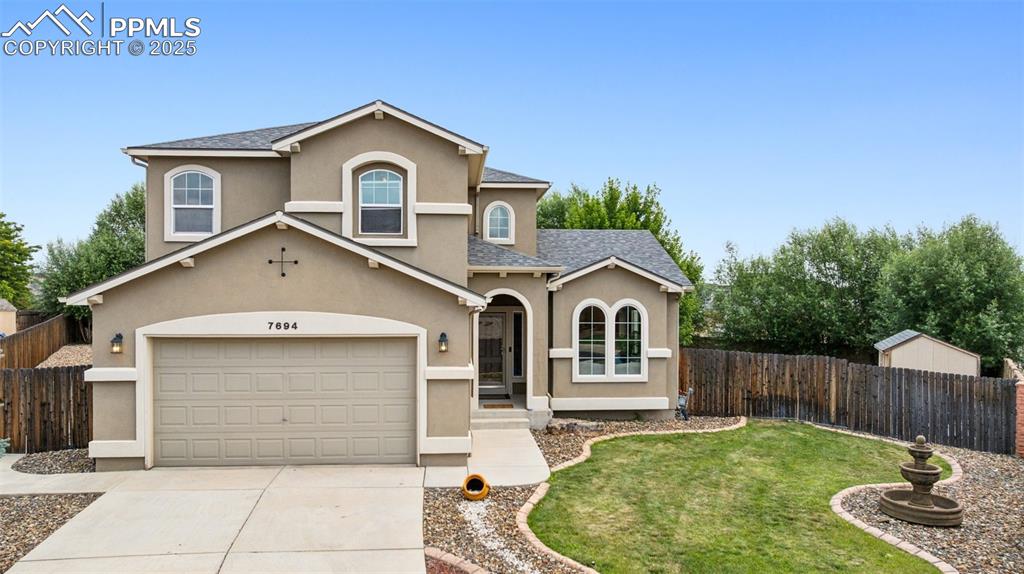 Caption: Traditional-style house featuring stucco siding, concrete driveway, 2 car attached garage, and 2 she