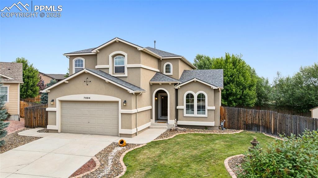 Image 2 of 46: Traditional-style house featuring stucco siding, driveway, a shingled roof,