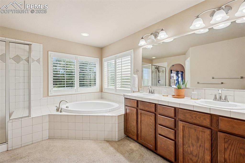 Image 25 of 46: Primary bathroom featuring double vanity, soaking tub, stand alone shower a