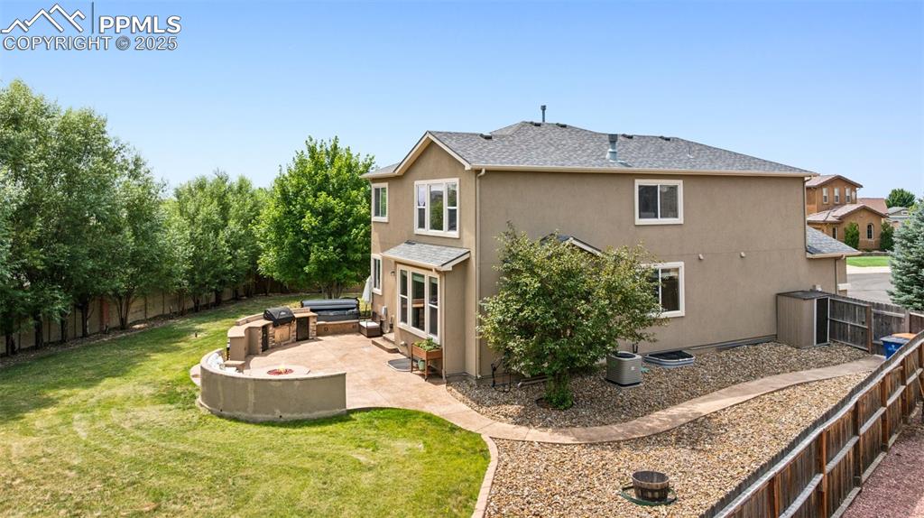 Image 3 of 46: Rear view of property with stucco siding, a patio, a fenced backyard, and r