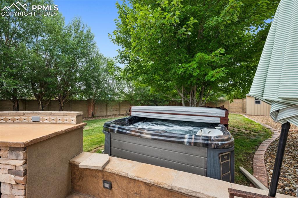 Image 5 of 46: Fenced backyard with a hot tub