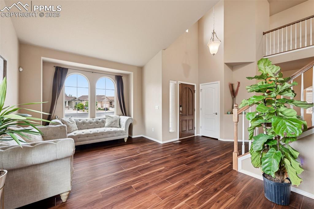 Image 7 of 46: Living room with wood finished floors and high vaulted ceilings