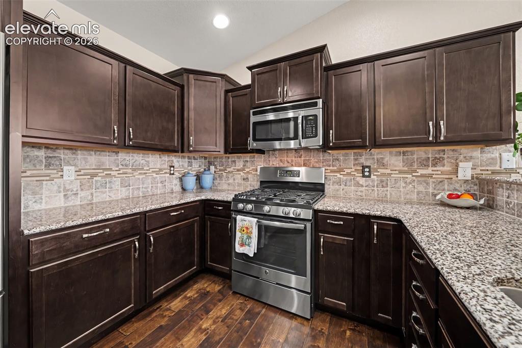 Image 12 of 32: Beautifully designed kitchen featuring granite countertops, travertine and