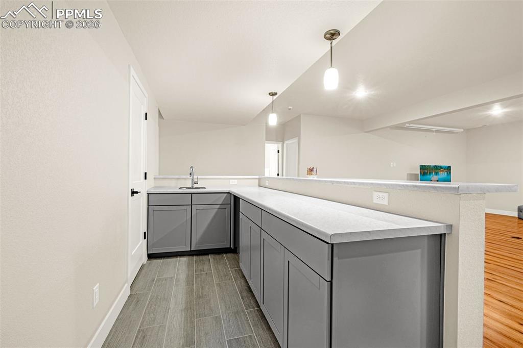 Image 19 of 38: wet bar in basement with storage closet behind