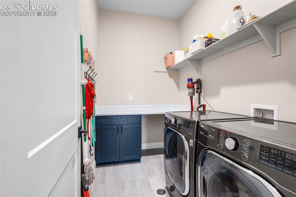 Image 27 of 38: main level laundry room with built in shelving 