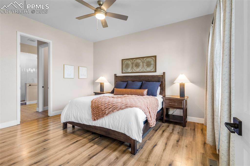 Image 9 of 38: main level primary bedroom with walk in closet and ensuite bathroom
