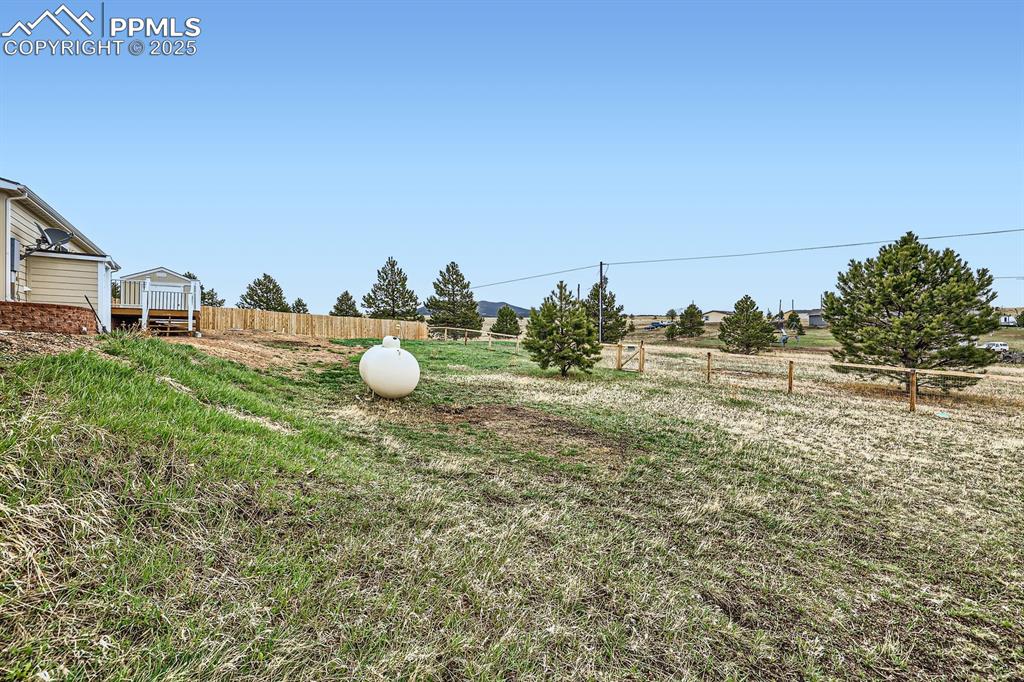 Image 35 of 41: View of yard featuring fence, a wooden deck, and a rural view