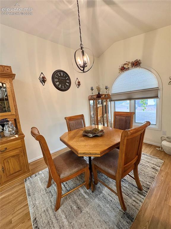 Image 10 of 28: Vaulted ceiling with an orb chandelier, hardwood-finish flooring, and arche