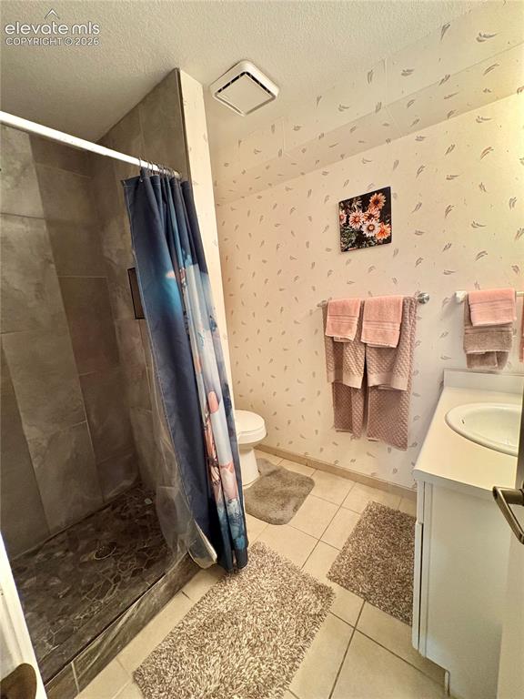 Image 20 of 28: Tiled flooring with a walk-in shower, a single vanity with an integrated si