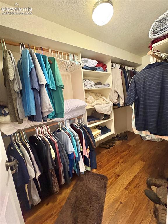 Image 21 of 28: Recessed lighting fixture, wood-finish flooring, built-in shelving, and han