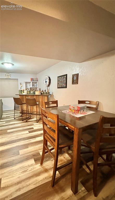 Image 22 of 28: Wood-finish flooring, built-in bar with shelving, recessed lighting, and a 