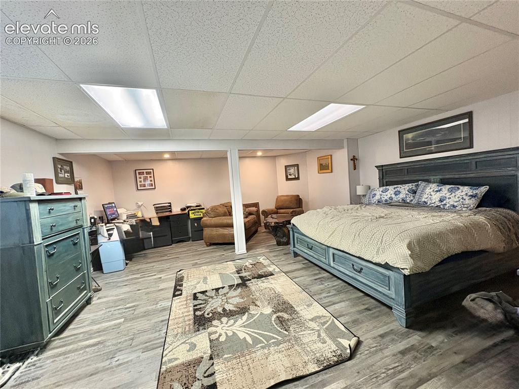 Image 24 of 28: Wood-finish flooring throughout, drop ceiling with recessed lighting, and a