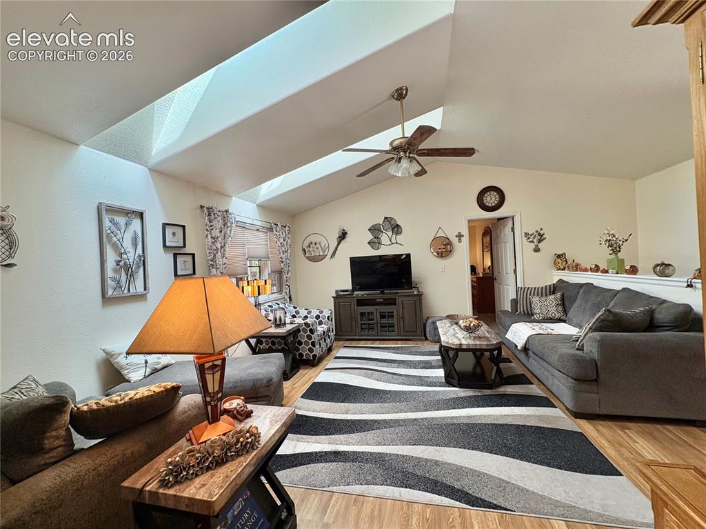 Image 4 of 28: Spacious open-concept living area flooded with natural light from a skyligh
