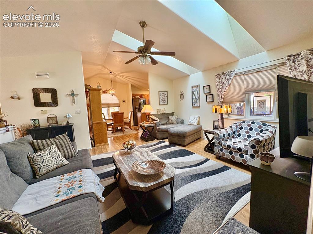 Image 5 of 28: Vaulted ceilings with skylights, wood-finish flooring, ceiling fan, and bui