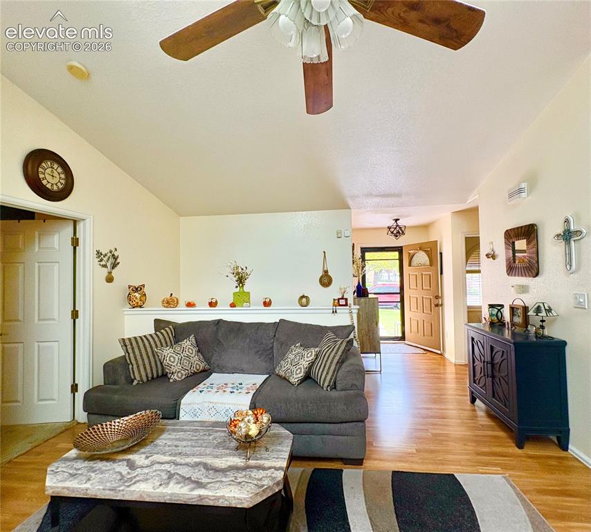 Image 6 of 28: Vaulted ceiling with a ceiling fan, wood-finish flooring, two-panel interio