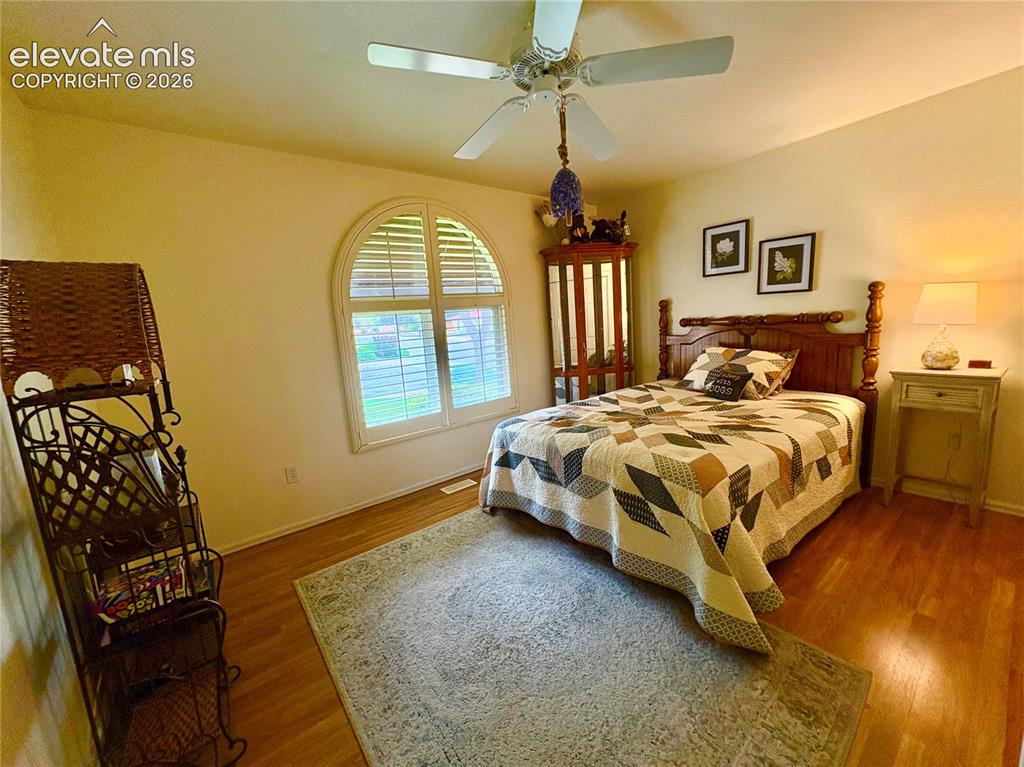 Image 8 of 28: Arch-top window with plantation shutters, ceiling fan with integrated light