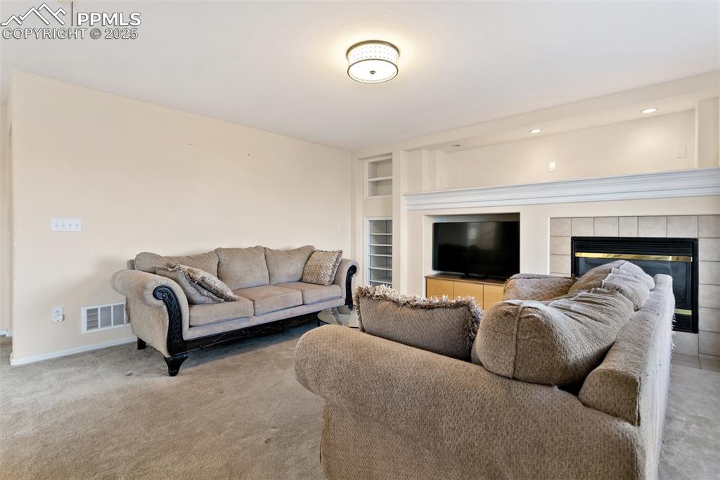 Image 15 of 48: Carpeted living room featuring built in features, baseboards, visible vents