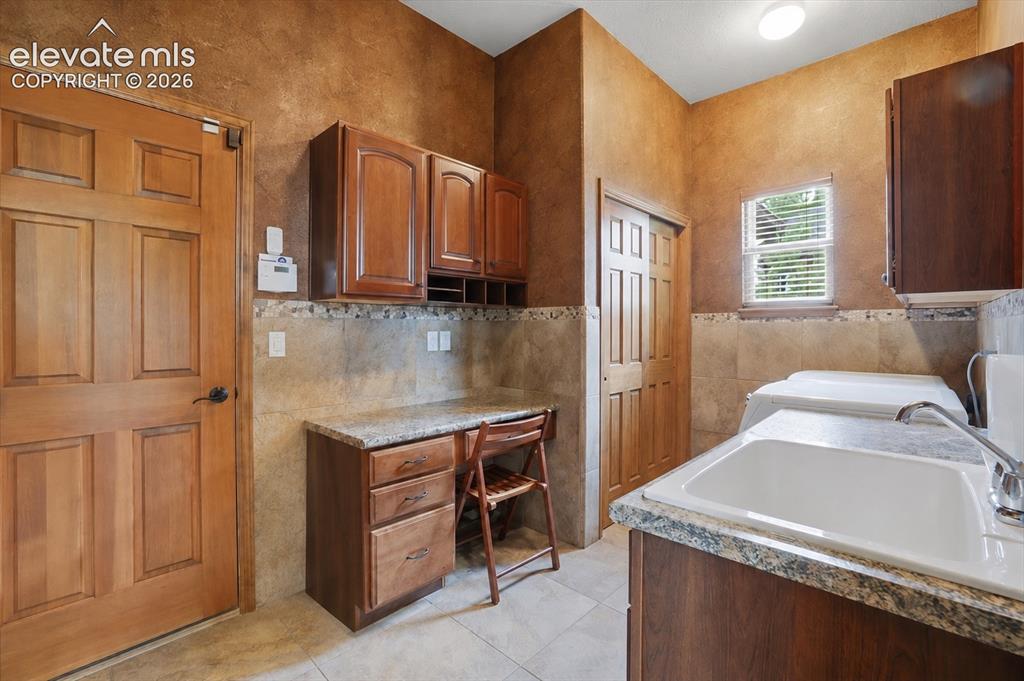 Image 20 of 32: Laundry/Mud Room has Sink and Workplace! Washer & Dryer included!