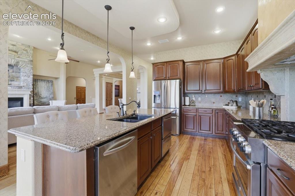 Image 9 of 32: Gourmet Kitchen with Wood Flooring, Island, Granite Countertops, Deco Tile