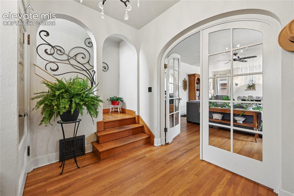 Image 5 of 50: Entry with steps to upstairs apartment and french doors to main living
