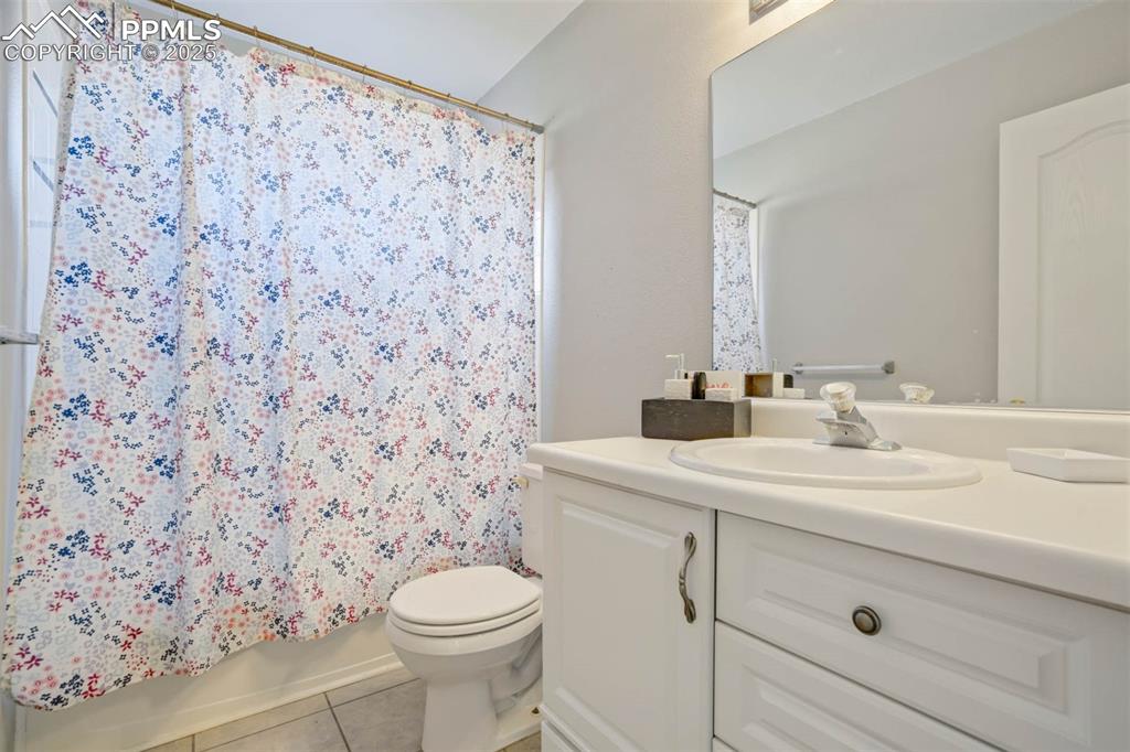 Image 21 of 27: Full bathroom with vanity, light tile patterned floors, and shower / bathtu