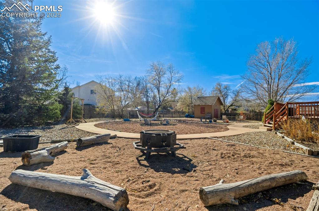 Image 38 of 39: View of yard with an outdoor fire pit, a patio, and an outbuilding
