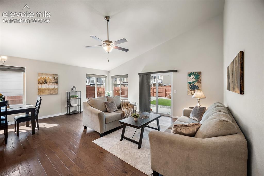Image 10 of 29: Vaulted ceiling, ceiling fan, wood-finish flooring, sliding glass door, and