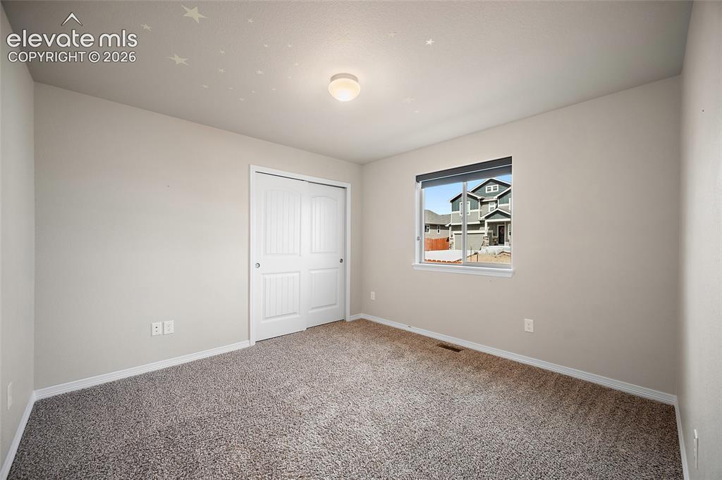 Image 14 of 29: Light gray wall paint with white trim, gray carpet flooring, and a white bi