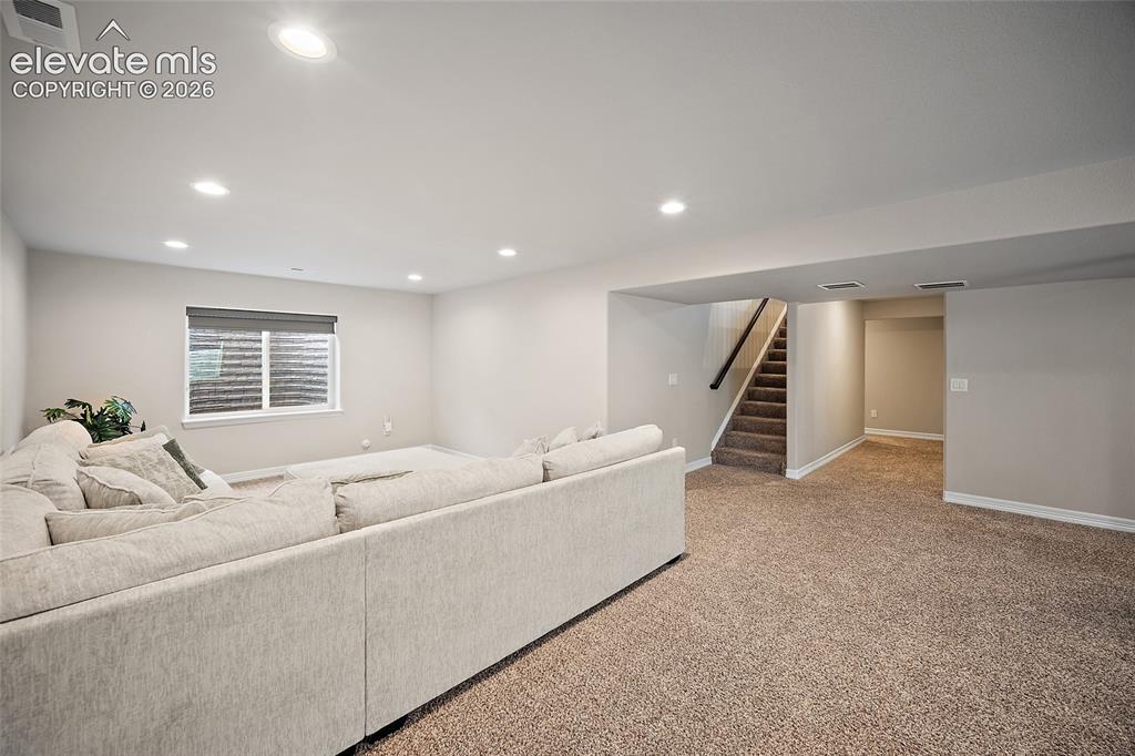 Image 18 of 29: Expansive lower level featuring recessed lighting, a window with blinds, ca