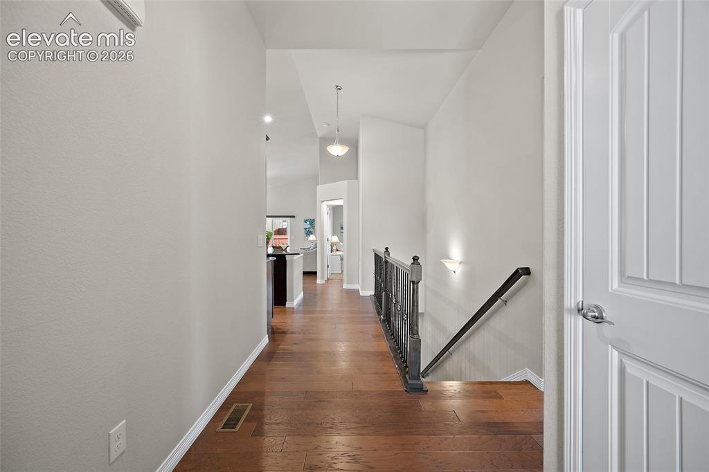 Image 2 of 29: Hardwood flooring throughout, leading to a staircase with a dark wood-finis