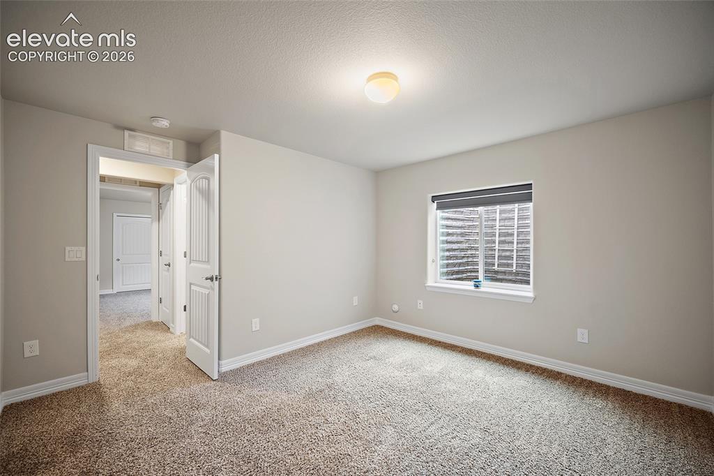Image 22 of 29: Plush carpeting, neutral wall color, overhead lighting, single window, and 