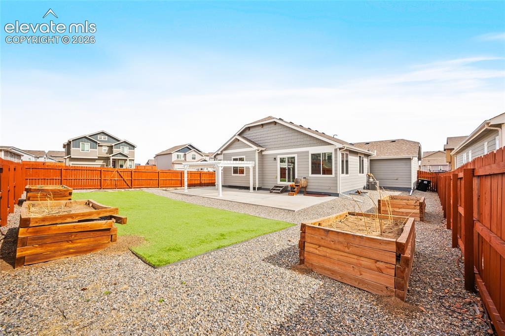 Image 28 of 29: Expansive backyard featuring a large concrete patio, artificial turf, two r