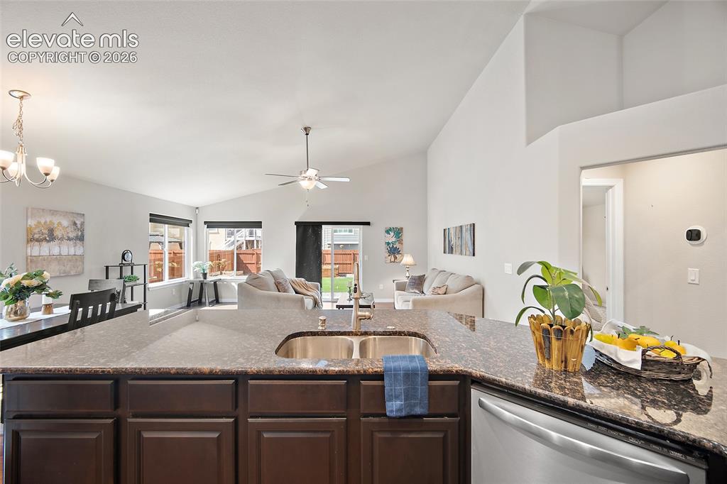 Image 4 of 29: Kitchen island with a double basin stainless steel sink, dark wood cabinetr