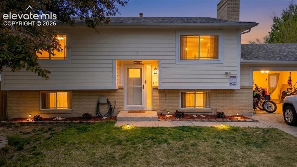 Image 1 of 50: Split-level residence featuring light-colored siding and a brick base