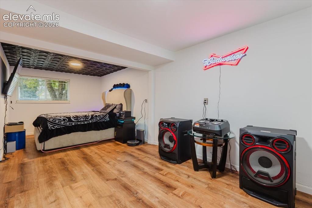Image 15 of 50: Spacious room featuring wood-finish flooring and a white wall finish